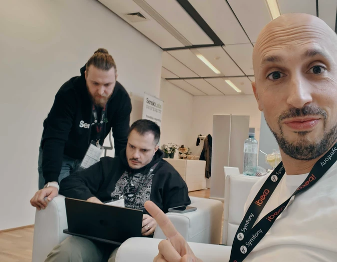 Trzech mężczyzn pracuje na laptopach w nowoczesnym biurze z brandingiem SensioLabs