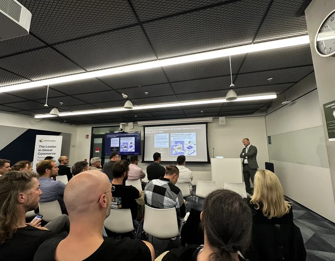 Publiczność oglądająca prezentację na temat handlu elektronicznego i integracji sztucznej inteligencji z brandingiem commercetools