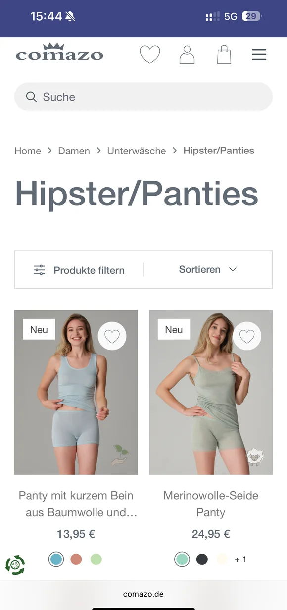 Mobilny interfejs e-commerce Comazo prezentujący listę produktów z bielizną damską, w tym majtki typu „Panty mit kurzem Bein” oraz „Merinowolle-Seide Panty” wraz z cenami i wariantami kolorystycznymi